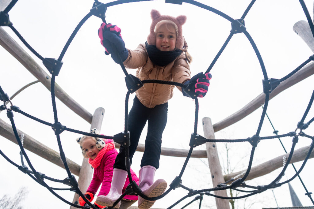 Kinderen in de winter op een speeltoestel van IJslander